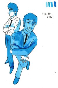 Two young men in suits in shades of blue, one standing with arms crossed, the other crouching in front and grinning up at the viewer.